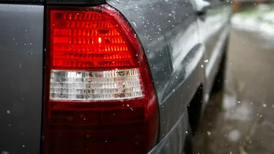 Red taillight of a gray car glows while snowflakes fall against the wet bodywork. Shallow depth of field and droplets highlight movement safety and winter driving atmosphere.,Image: 1093484948, License: Royalty-free, Restrictions:, Model Release: no 