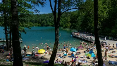 People enjoy a warm weather by a lake near Vilnius, Lithuania, Saturday, June 27, 2026. (AP Photo/Mindaugas Kulbis)