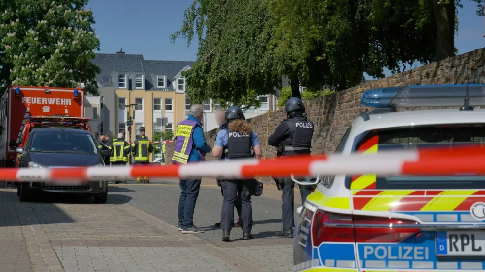 08 May 2026, Rhineland-Palatinate, Sinzig: Police officers and police vehicles stand behind barrier tape. According to initial police reports, a hostage situation has occurred at a bank branch in Sinzig, Rhineland-Palatinate. The emergency services are on the scene with a large contingent in the Ahrweiler district. Photo: Sascha Ditscher/dpa - ATTENTION: Civilian person and identification number(s) have been pixelated for legal reasons,Image: 1097317297, License: Rights-managed, Restrictions: GERMANY OUT, Model Release: no