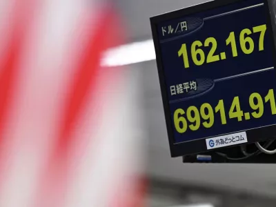 An electronic board shows Japan's benchmark Nikkei 225 index, bottom, and exchange rate of the Japanese yen against the U.S. dollar in Tokyo Tuesday, June 30, 2026. (Kenichiro Kojima/Kyodo News via AP)