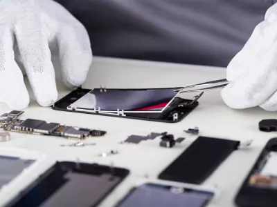 Close-up Of Repairman Disassembling Smartphone With Tweezers