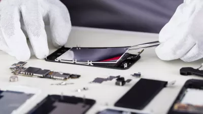 Close-up Of Repairman Disassembling Smartphone With Tweezers