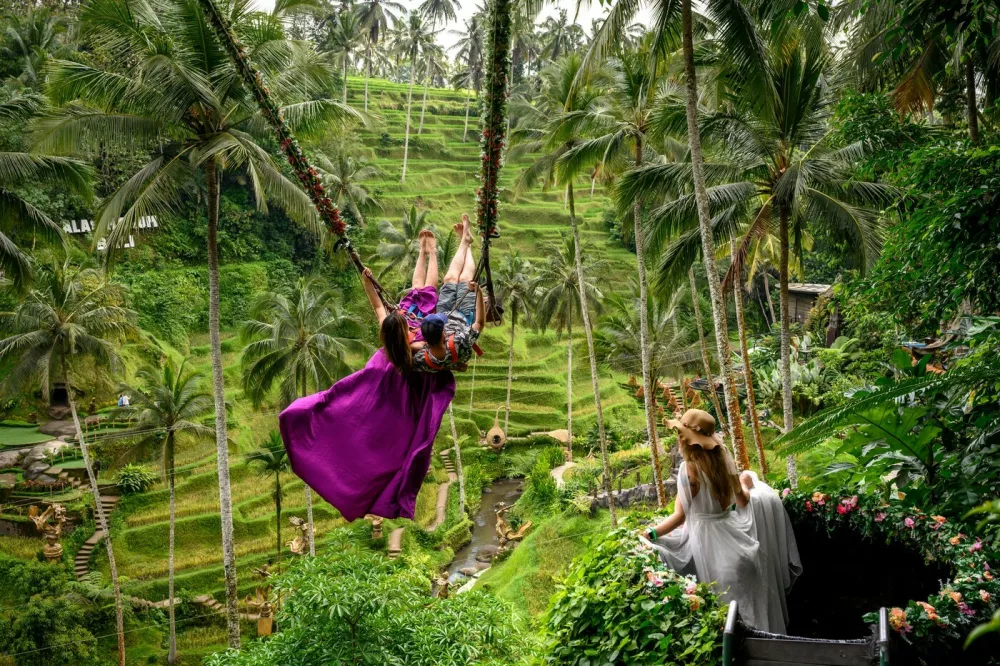 A couple poses for photographs on a giant swing at the Tegallalang rice terraces near Ubud in Bali on November 5, 2025.,Image: 1050469943, License: Rights-managed, Restrictions:, Model Release: no 