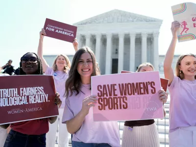 Women hold placards as they celebrate the U.S. Supreme Court's final rulings of its nine-month term, including a decision that cleared the way for states to impose restrictions on transgender student athletes, upholding laws in West Virginia and Idaho banning them from female sports teams, in Washington, D.C., U.S., June 30, 2026. REUTERS/Cheney Orr  REFILE - ADDING INFORMATION