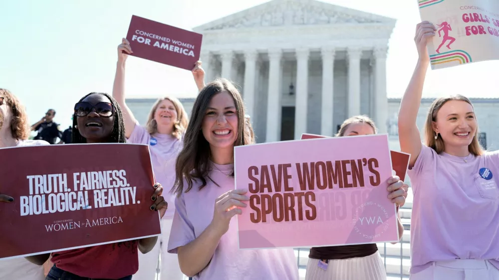 Women hold placards as they celebrate the U.S. Supreme Court's final rulings of its nine-month term, including a decision that cleared the way for states to impose restrictions on transgender student athletes, upholding laws in West Virginia and Idaho banning them from female sports teams, in Washington, D.C., U.S., June 30, 2026. REUTERS/Cheney Orr  REFILE - ADDING INFORMATION