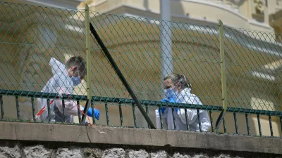 Investigators examine the scene at the residential building where an explosive device seriously injured three people a day earlier in Monaco, Tuesday, June 30, 2026. (AP Photo/Philippe Magoni)