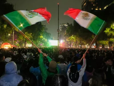 Mexican fans wave flags as they watch the World Cup round of 32 soccer match between Mexico and Ecuador near the Angel of Independence monument in Mexico City, Tuesday, June 30, 2026. (AP Photo/Marco Ugarte)