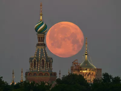 The full moon sets behind the Saviour of Spilled Blood Cathedral in St. Petersburg, Russia, early Wednesday, July 1, 2026. (AP Photo/Dmitri Lovetsky)