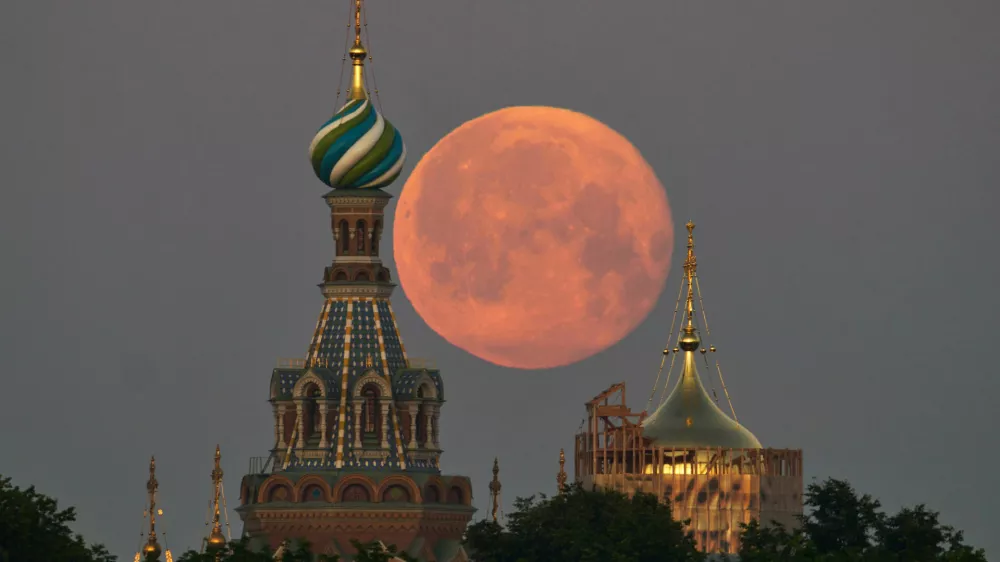 The full moon sets behind the Saviour of Spilled Blood Cathedral in St. Petersburg, Russia, early Wednesday, July 1, 2026. (AP Photo/Dmitri Lovetsky)