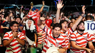 U.S. soccer fans, including Caleb Triana, center, and Nicolas Cerda, dressed as a founding father, celebrate the U.S. scoring its second goal, as they watch a live broadcast of the World Cup round of 32 soccer match between the United States and Bosnia, Wednesday, July 1, 2026, at an official fan fest in downtown Miami. (AP Photo/Rebecca Blackwell)