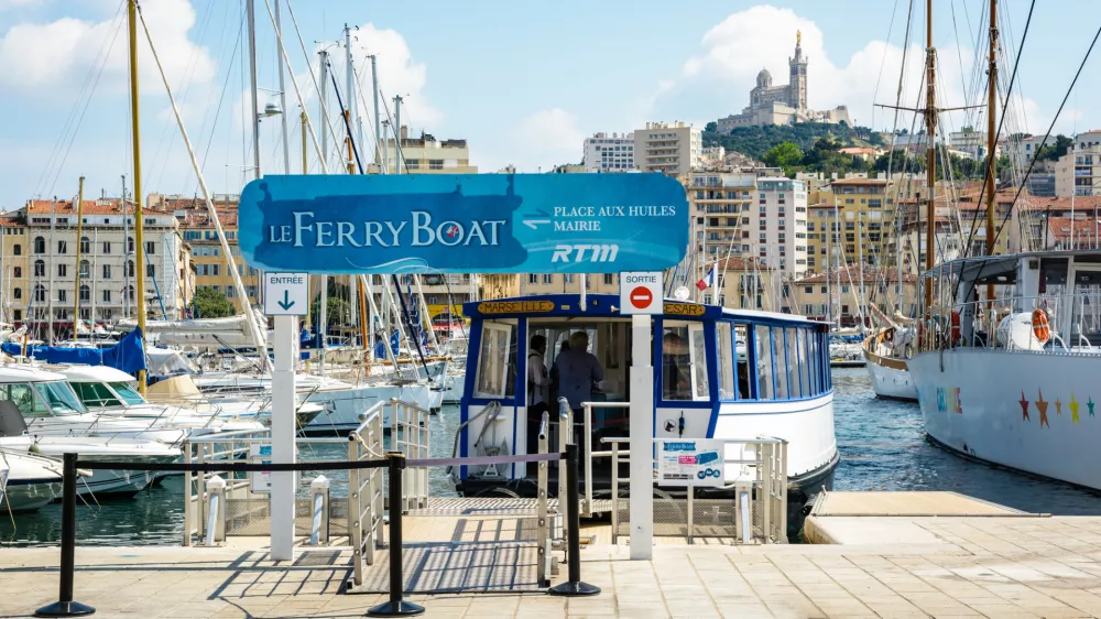 Marseille, France - May 17, 2018: The Ferry Boat, a public maritime shuttle run today by the RTM, allows to cross the Old Port of Marseille since 1880, under the protection of Notre-Dame de la Garde.