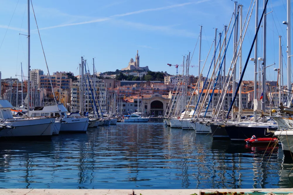 Panoramic view of the Old Port of Marseille, Vieux-Port. Looking towards the Cathedral de Notre-Dame-de-la-Garde high on a hill overlooking the city. June 17, 2019. Marseille, France