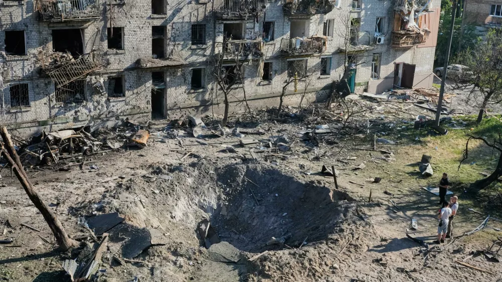 People look at the site of a Russian missile strike that hit a residential building in Kyiv, Ukraine, Thursday, July 2, 2026. (AP Photo/Efrem Lukatsky)