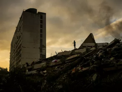 A man stands atop a mountain of rubble three days after twin earthquakes struck, in La Guaira, Venezuela, Saturday, June 27, 2026. (AP Photo/Matias Delacroix)