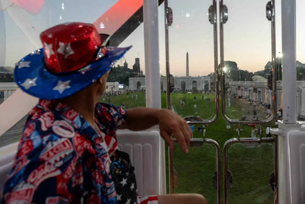 Logan Otto, 68, looks out towards the Washington Monument while riding the Ferris wheel at The Great American State Fair on the National Mall in Washington, D.C., U.S., July 2, 2026. REUTERS/Cheney Orr