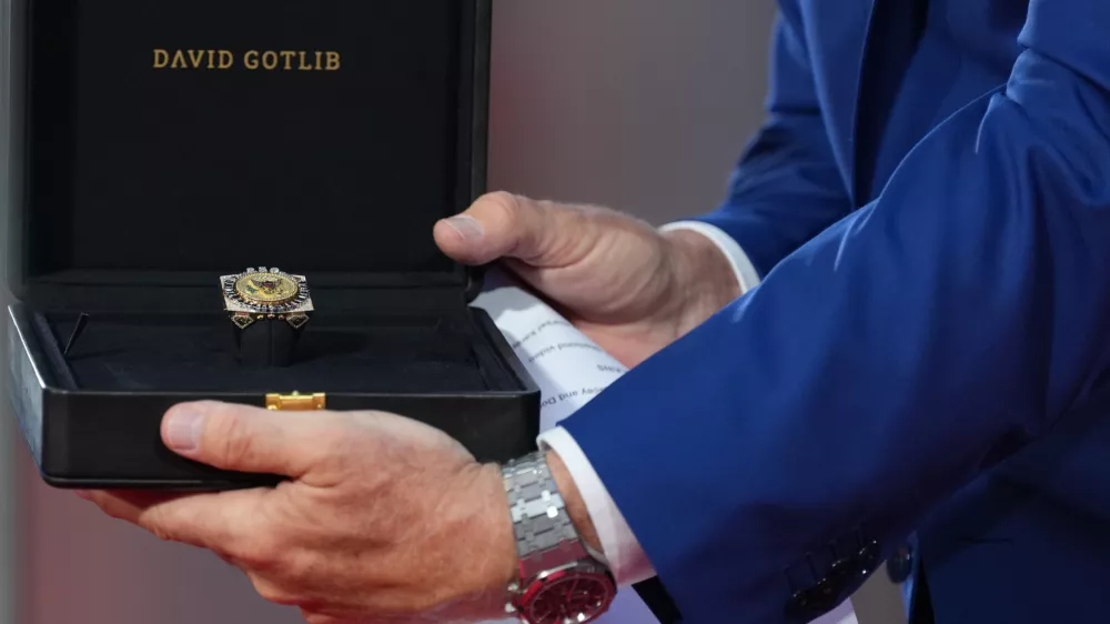 U.S. Ambassador to Belgium Bill White presents a ring designed for U.S. President Donald Trump and crafted by Antwerp diamond designer David Gotlib, during the America 250 event in Brussels, Sunday, June 28, 2026. (AP Photo/Virginia Mayo)
