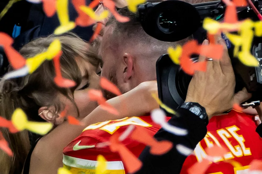 FILE PHOTO: Football - NFL - Super Bowl LVIII - Kansas City Chiefs v San Francisco 49ers - Allegiant Stadium, Las Vegas, Nevada, United States - February 11, 2024 Kansas City Chiefs' Travis Kelce kisses partner Taylor Swift as they celebrate after Kansas City Chiefs win Super Bowl LVIII REUTERS/Carlos Barria/File Photo