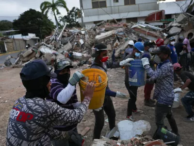 Rescuers pass rubble in buckets as they search through debris in the aftermath of the June 24 earthquakes, in La Guaira, Venezuela, July 4, 2026. REUTERS/Pablo Sanhueza