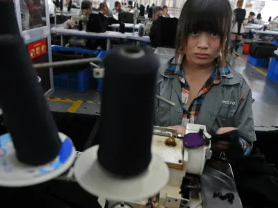 A college student looks up as she works at a garment factory in Jiaxing, Zhejiang province, October 19, 2012. More and more factories in China move inland from higher-cost coastal manufacturing centers, labor is turning out to be neither as cheap nor abundant as many companies believed. As a result, many multinationals and their suppliers are corralling millions of teenage vocational students to work long hours doing assembly line jobs that might otherwise go unfilled - jobs that the students have no choice but to accept. Picture taken October 19, 2012. REUTERS/Stringer (CHINA - Tags: BUSINESS) CHINA OUT. NO COMMERCIAL OR EDITORIAL SALES IN CHINA