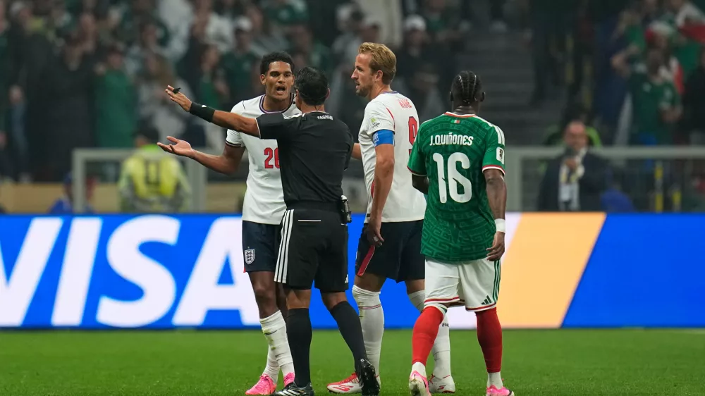 England's Jarell Quansah reacts next to England's Harry Kane and referee Alireza Faghani after receiving a red card during the World Cup round of 16 soccer match between Mexico and England in Mexico City, Sunday, July 5, 2026. (AP Photo/Ricardo Mazalan)