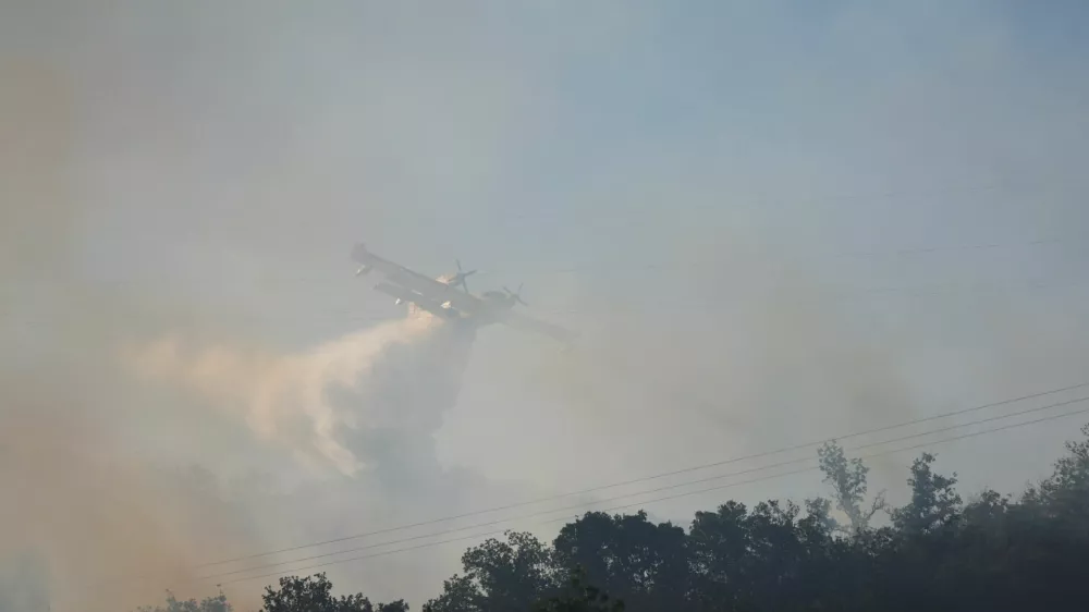 A firefighting plane drops water, following a wildfire in Ille-sur-Tet near Perpignan, France, July 6, 2026. REUTERS/Bruna Casas