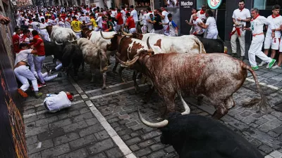 Revelers run alongside Fuente Ymbro's fighting bulls during the first running of the bulls at the San Ferm&iacute;n festival in Pamplona, Spain, Tuesday, July 7, 2026. (AP Photo/Miguel Oses)