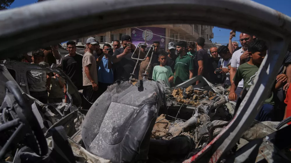 Palestinians gather around a car hit in an Israeli military strike that, according to health authorities, killed at least one person in Gaza City, Thursday, July 9, 2026. (AP Photo/Jehad Alshrafi)