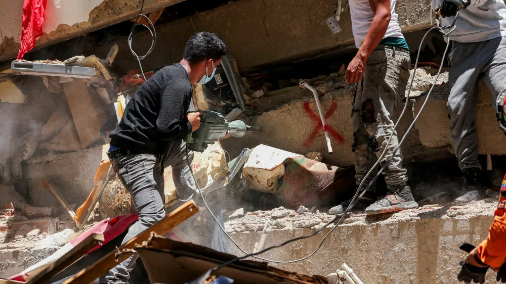 Rescuers work as they help members of Argentina's La Matanza Rescue Team (not pictured) to recover bodies in the Tanaguarena area of Caraballeda, in the aftermath of the deadly June 24 earthquakes, La Guaira state, Venezuela July 7, 2026. REUTERS/Leonardo Fernandez Viloria