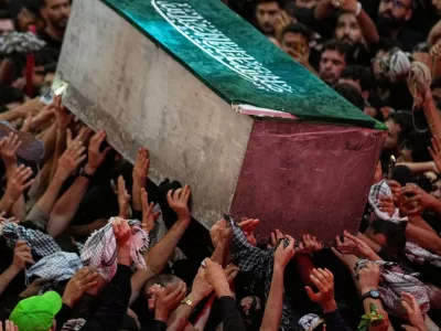 The coffin of the late Iranian Supreme Leader Ayatollah Ali Khamenei is carried through a crowd as mourners jostle to reach and touch it outside the Imam Hussein Shrine in Karbala, Iraq, early Thursday, July 9, 2026. (AP Photo/Khalil Hamra)