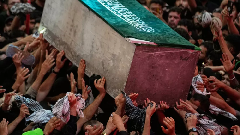 The coffin of the late Iranian Supreme Leader Ayatollah Ali Khamenei is carried through a crowd as mourners jostle to reach and touch it outside the Imam Hussein Shrine in Karbala, Iraq, early Thursday, July 9, 2026. (AP Photo/Khalil Hamra)