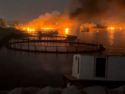 Smoke rises from a port, near Strait of Hormuz, following a U.S. strike in Kuhestak, Hormozgan Province, Iran, July 8, 2026, in this screengrab obtained from a social media video. Social Media/via REUTERS THIS IMAGE HAS BEEN SUPPLIED BY A THIRD PARTY. MANDATORY CREDIT. NO RESALES. NO ARCHIVES. NEWS USE ONLY. Verification line: Reuters confirmed the location by matching the port layout visible in the video with satellite imagery. The coordinates are 26.801109802855272, 57.02121784040872. The date the video was filmed was verified through a report from Iran's semi-official Mehr News Agency, which reported explosions early on July 8 at multiple locations along the Gulf coast, including Kuhestak. Aftermath photographs shared online on July 8 also showed damage at the same location. No earlier versions of the footage or photographs posted before July 8 were found.