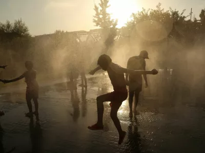 People cool off between jets of water at Madrid Rio park during a heatwave in Madrid, Spain, July 8, 2026. REUTERS/Susana Vera