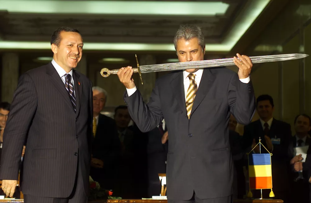 ROMANIAN PRIME MINISTER NASTASE KISSES A SWORD WHILE HIS TURKISH COUNTERPART ERDOGAN WATCHES IN BUCHAREST. Romanian Prime Minister Adrian Nastase (R) kisses a copy of the sword of Romania's 15th century national hero, Stefan cel Mare, given as a gift by his visiting Turkish counterpart Recep Tayyip Erdogan (L) at Victoria palace in Bucharest May 20, 2004. The original medieval sword is kept at Istanbul's Topkapi Museum. REUTERS/Bogdan Cristel