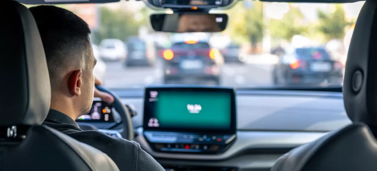 A male driver drives at speed through the streets of the city, a view from inside the car.