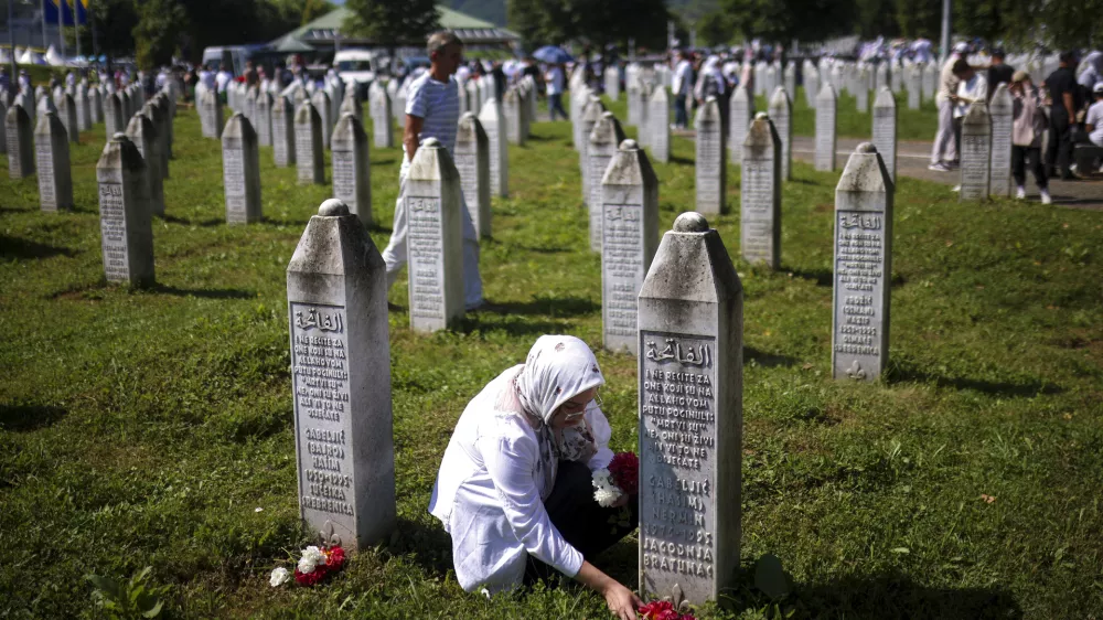 A Bosnian muslim woman lays flowers at the grave of her relative, victim of the Srebrenica genocide, at the Srebrenica Memorial Centre, in Potocari, Bosnia, Thursday, July 11, 2024. Thousands gather in the eastern Bosnian town of Srebrenica to commemorate the 29th anniversary on Monday of Europe's only acknowledged genocide since World War II. (AP Photo/Armin Durgut)
