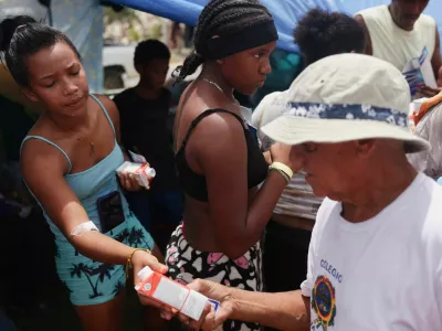 Displaced people gather to receive aid at a makeshift shelter run by the United Nations at a baseball field, in the aftermath of the June 24 earthquakes, in Catia La Mar, La Guaira state, Venezuela, July 9, 2026. REUTERS/Leonardo Fernandez Viloria