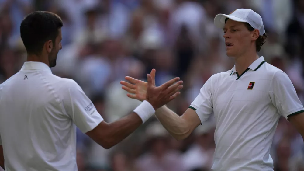 Novak Djokovic of Serbia, left, and Jannik Sinner of Italy greet each other at the end of their men's singles semifinal match at the Wimbledon Tennis Championships in London, Friday, July 10, 2026. (AP Photo/Brian Inganga)