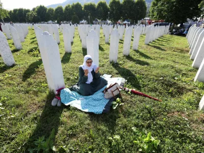 A Bosnian woman prays near the grave stones of victims during a memorial ceremony and funeral for ten victims, marking the 31st anniversary of the Srebrenica genocide in Potocari, Bosnia and Herzegovina, July 11, 2026. REUTERS/Amel Emric