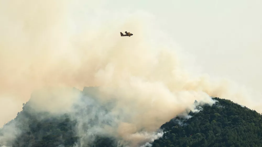 A firefighting plane flies over a wildfire that has been ravaging mountain vegetation for several days near Die in the Drome department during a heatwave affecting a large part of the country, France, July 9, 2026. REUTERS/Manon Cruz