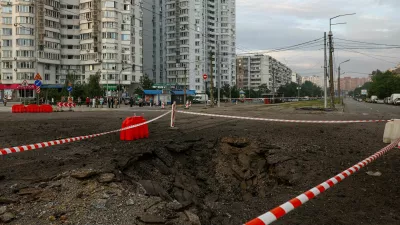 Residents gather next to a crater that appeared after Russian missile strikes, amid Russia's attack on Ukraine, in Kyiv, Ukraine July 11, 2026. REUTERS/Valentyn Ogirenko