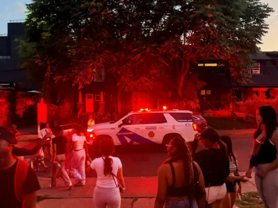 A police vehicle makes its way as people gather near the scene after a deadly shooting, at a salsa-themed street festival in Toronto, Ontario, Canada, July 11, 2026. Picture taken using a mobile phone. REUTERS/Cole Burston