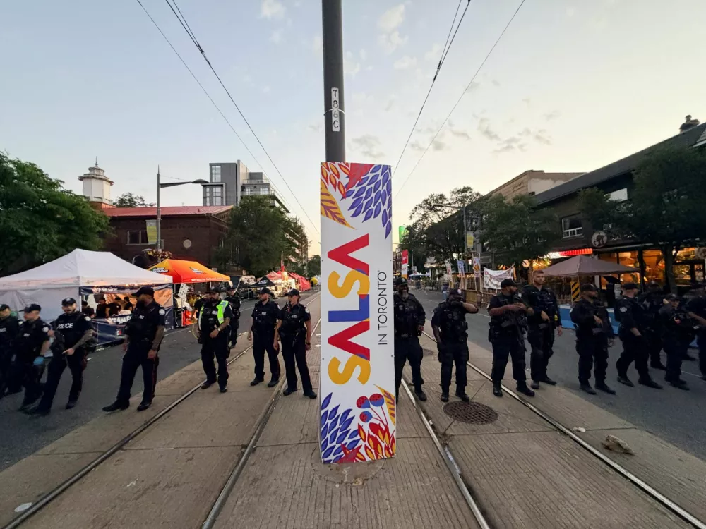 Police officers stand guard at the site of a deadly shooting, at a salsa-themed street festival in Toronto, Ontario, Canada, July 11, 2026. Picture taken using a mobile phone. REUTERS/Cole Burston