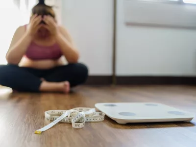 Obese Woman with fat upset bored of dieting Weight loss fail&Acirc;&nbsp; Fat diet and scale sad asian woman on weight scale at home weight control.