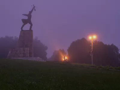 A couple stand near the monument "Peremilovskaya Heights", in Peremilovo village, about 70 kilometers (44 miles) north from Moscow, Russia, before sunrise, Sunday, July 12, 2026. (AP Photo/Alexander Zemlianichenko)