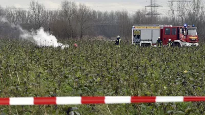Firefighters stand at the area of a plane and helicopter crash near Philippsburg, Germany, Monday, Jan. 23, 2018. German police say a small aircraft has crashed midair with a helicopter northwest of Stuttgart. Police in Karlsruhe told the dpa news agency Tuesday the two aircraft crashed outside of Philippsburg, about 100 kilometers (60 miles) from Stuttgart. (Rene Priebe/dpa via AP)