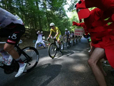 Cycling - Tour de France - Stage 9 - Malemort to Ussel - Malemort, France - July 12, 2026 UAE Team Emirates - XRG's Tadej Pogacar wearing the yellow jersey, UAE Team Emirates - XRG's Isaac Del Toro wearing the white jersey and Team Visma | Lease a Bike's Jonas Vingegaard wearing the polka-dot jersey in action as a spectator dressed in a costume cheers on during stage 9 REUTERS/Gonzalo Fuentes