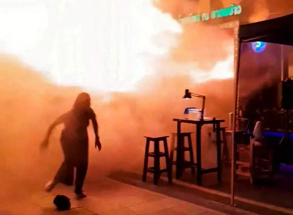 A person runs as flames rise at a pub in Bangkok, Thailand, in this screengrab taken from a social media video released July 13, 2026. txng.di.kwa.deim.hi.di via Facebook/via REUTERS THIS IMAGE HAS BEEN SUPPLIED BY A THIRD PARTY. MANDATORY CREDIT. NO RESALES. NO ARCHIVES. THIS PICTURE WAS PROCESSED BY REUTERS TO ENHANCE QUALITY. AN UNPROCESSED VERSION HAS BEEN PROVIDED SEPARATELY.  Verification: - Business signage, road layout, bridge and steel poles matched archive image and Reuters aftermath coverage. - Time of footage recorded was not confirmed, however, Thai officials confirmed that the fire broke out at 11:57 p.m. (1657 GMT) on Sunday (July 12). - Corroborating footage posted online on Monday (July 13) also showed similar intensity flames bursting out from the location.