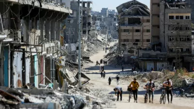 FILE PHOTO: Palestinians make their way in a devasted neighborhood, amid the ongoing Israel-Hamas conflict, in Gaza City, October 24, 2024. REUTERS/Dawoud Abu Alkas/File Photo