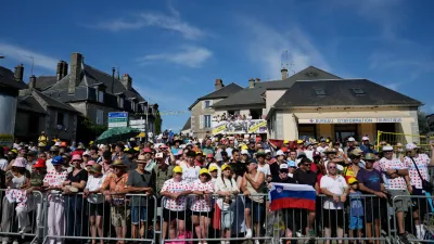 Spectators wait for the riders to pass during the ninth stage of the Tour de France cycling race with start in Malemort and finish in Ussel, France, Sunday, July 12, 2026. (AP Photo/Mosa'ab Elshamy)