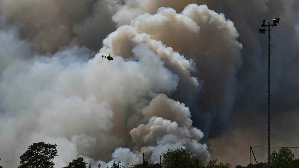 A fire fighting helicopter in action as wildfires are seen in the Fontainebleau forest region, about 60 kilometers (37 miles) south of Paris, France, Monday, July 13, 2026. (AP Photo/Emma Da Silva)